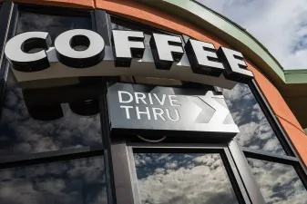Dimensional COFFEE lettering above a drive-through entrance